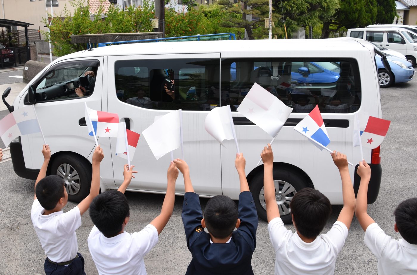 Children in Imabari, Japan waving Panama flags to welcome visiting guests